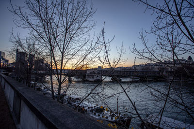 Bridge over river against sky at sunset