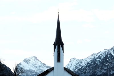 Low angle view of snow covered mountain against sky