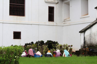 Rear view of people sitting outside building