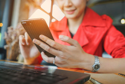 Midsection of woman using mobile phone