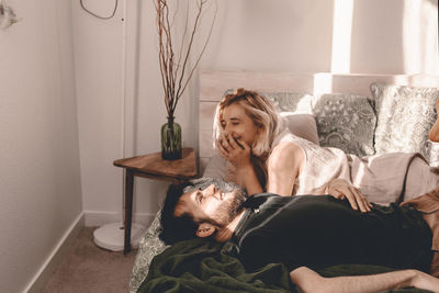 Happy couple lying on bed at home