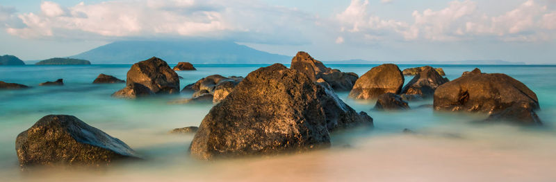 Panoramic view of rocks on sea against sky