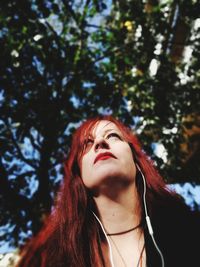 Portrait of young woman against tree