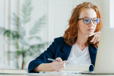 Businesswoman using laptop on desk in office