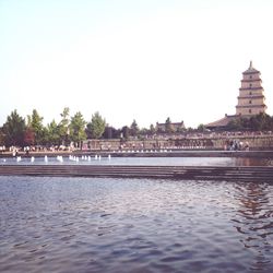 Built structure by river against clear sky