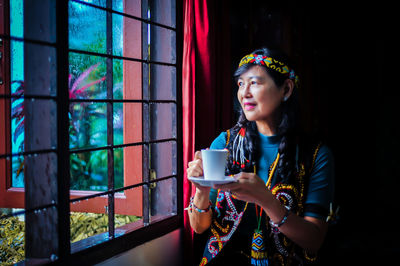 Portrait of young woman having drink at home