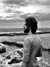 Man standing at beach against sky