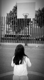 Rear view of girl standing on road