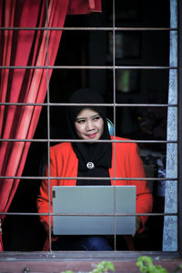 Young woman looking through window