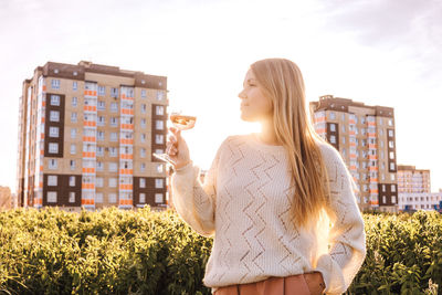 Woman standing in front of building against sky