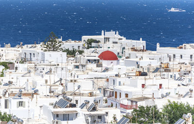 High angle view of townscape by sea against blue sky