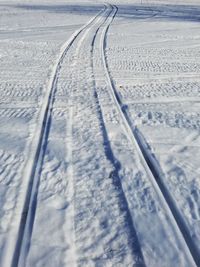 Tire tracks on snow covered landscape