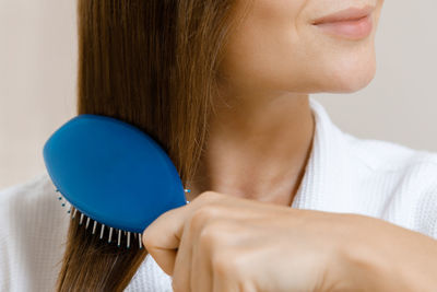 Midsection of woman combing hair