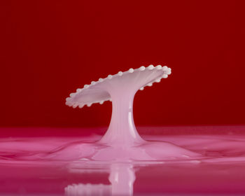 Close-up of splashing water against red background