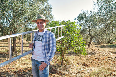 Portrait of smiling man standing on field