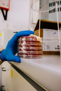 Cropped hand of scientist holding laboratory glassware on table