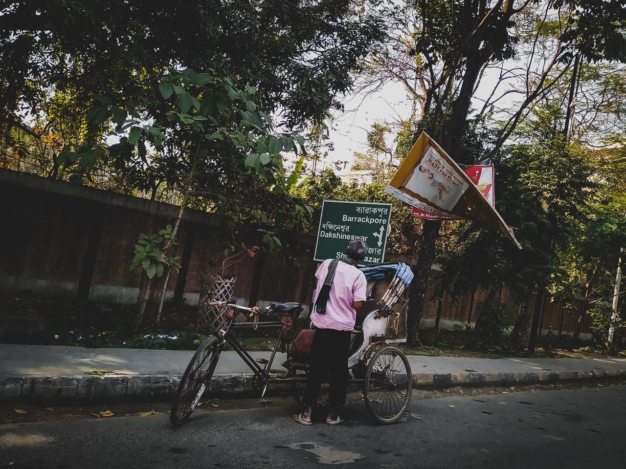 REAR VIEW OF PERSON RIDING BICYCLE ON ROAD