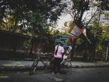 Rear view of man riding bicycle on street