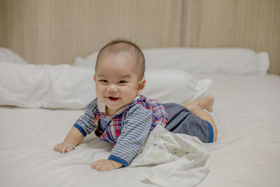 Cute baby girl lying on bed