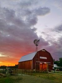 Houses against cloudy sky at sunset