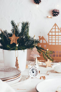 White alarm clock, plates, spruce bouquet and christmas decorations