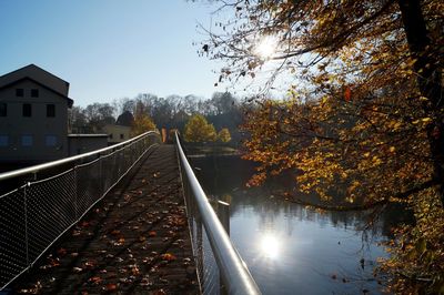 Footbridge over lake against sky