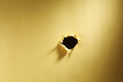 Full frame shot of yellow paper with hole