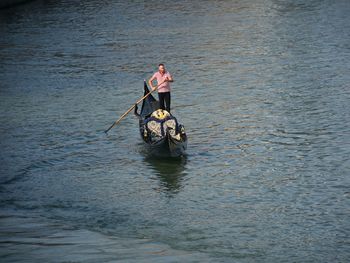 High angle view of gondolier oaring gondola in canal