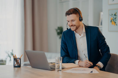 Man using mobile phone while sitting on table