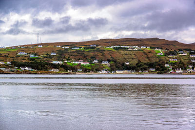 Scenic view of sea by buildings against sky