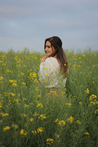 Side view of woman standing amidst plants