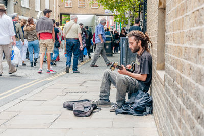 Men sitting on street in city