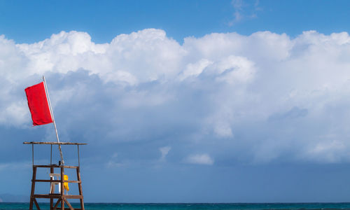 Lifeguard chair against cloudy sky