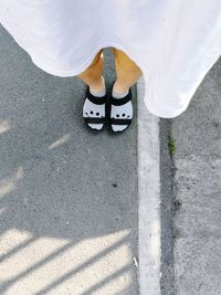 Low section of woman standing on road