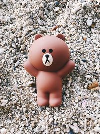 Close-up of hand holding toy on stone