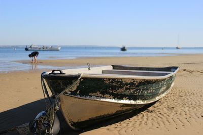 Close-up of boat on beach against clear sky