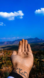 Midsection of person on mountain against sky