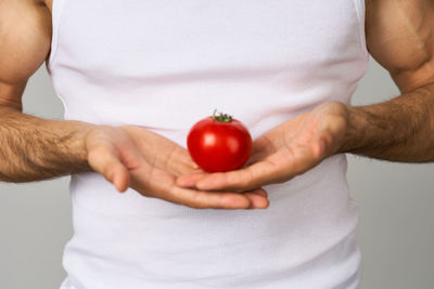 Midsection of man holding strawberry