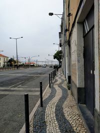 Street by road against sky in city