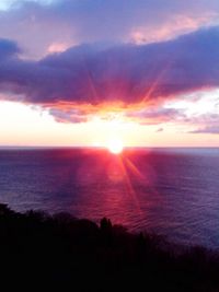 Scenic view of sea against dramatic sky during sunset