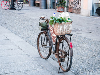 Bicycle on footpath by street against buildings