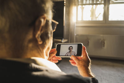 Midsection of man using mobile phone