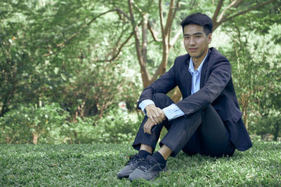 Full length of a young man sitting on land
