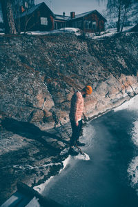 High angle view of mid adult man standing by lake during winter