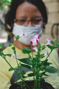 Close-up portrait of woman holding flowering plant