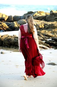 Rear view of woman with umbrella on beach