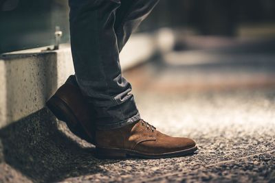 Low section of man wearing shoes standing outdoors