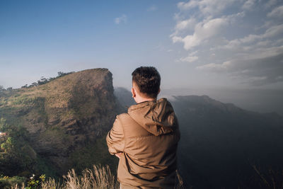 Rear view of man standing against sky