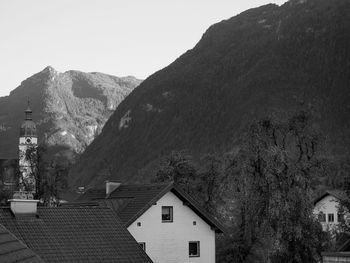 Houses by mountain against clear sky