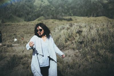 Smiling young woman standing on landscape